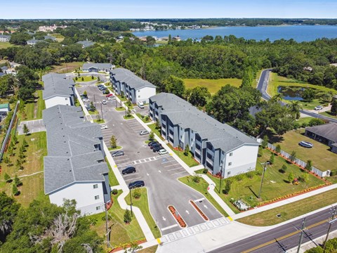 an aerial view of apartment buildings with a lake in the background